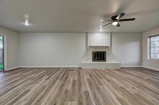 unfurnished living room featuring baseboards, light wood-style floors, and ceiling fan