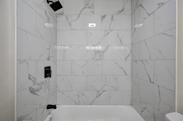 bathroom featuring toilet and bathtub / shower combination