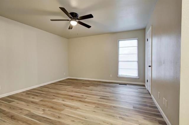 empty room with baseboards, light wood finished floors, and ceiling fan