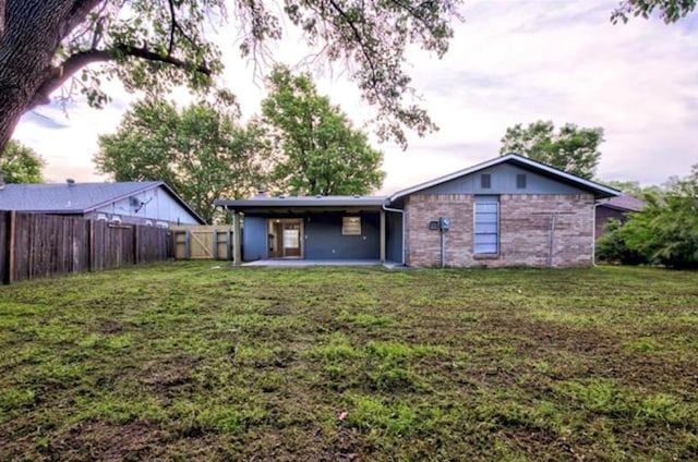 back of property featuring a fenced backyard, a patio area, and a yard
