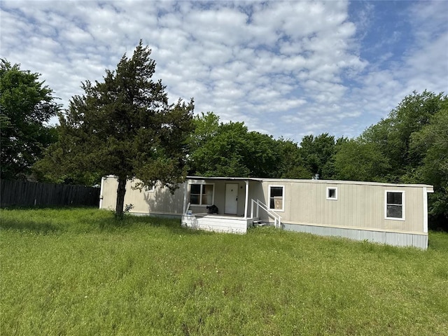 back of property featuring a porch, fence, and a yard