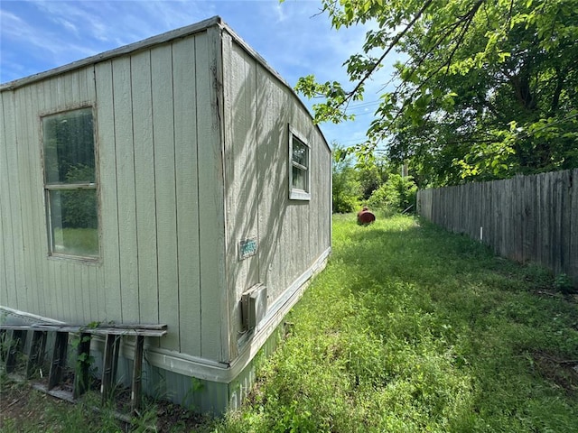 view of side of property featuring a lawn and fence