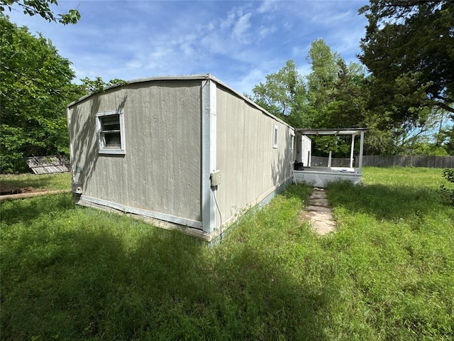view of home's exterior with a yard and fence
