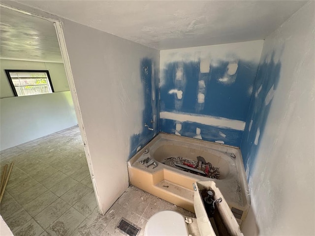 full bath with toilet, a garden tub, and visible vents