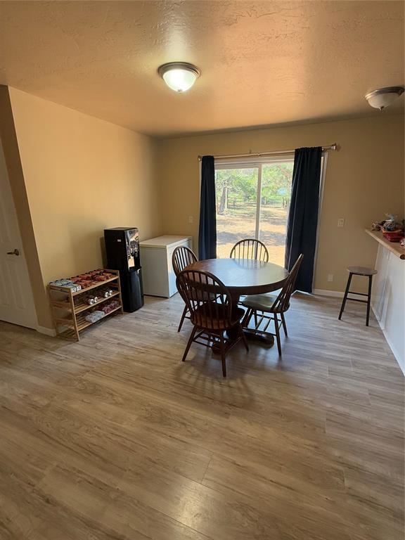 30738 NW Reno Rd, Hinton, OK 73047 - dining area with a textured ceiling, baseboards, and wood finished floors