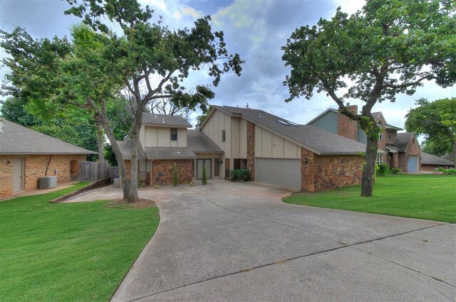 904 Carfax Rd, Edmond, OK 73034 - view of front of house with driveway, stone siding, an attached garage, and board and batten siding