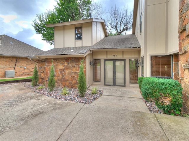 904 Carfax Rd, Edmond, OK 73034 - property entrance featuring roof with shingles and stone siding