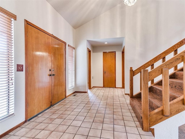 904 Carfax Rd, Edmond, OK 73034 - entrance foyer with high vaulted ceiling, light tile patterned floors, and stairs