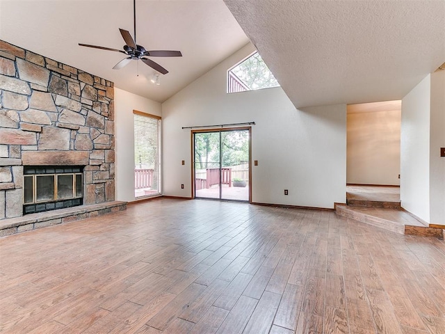 904 Carfax Rd, Edmond, OK 73034 - unfurnished living room featuring healthy amount of natural light, a ceiling fan, wood finished floors, high vaulted ceiling, and a fireplace