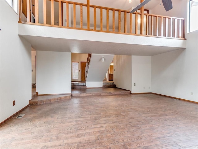 904 Carfax Rd, Edmond, OK 73034 - unfurnished living room with a high ceiling, wood finished floors, and stairs