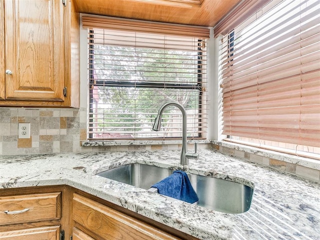 904 Carfax Rd, Edmond, OK 73034 - kitchen view of tasteful backsplash, light stone countertops, and brown cabinets