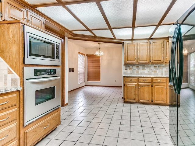 904 Carfax Rd, Edmond, OK 73034 - kitchen featuring appliances with stainless steel finishes, light tile patterned flooring, tasteful backsplash, a chandelier, and light stone countertops