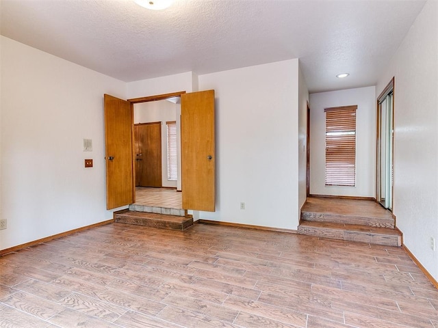 904 Carfax Rd, Edmond, OK 73034 - unfurnished room with wood finished floors and a textured ceiling