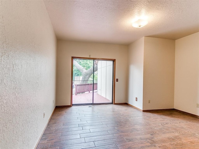 904 Carfax Rd, Edmond, OK 73034 - spare room featuring a textured wall, a textured ceiling, and wood finished floors