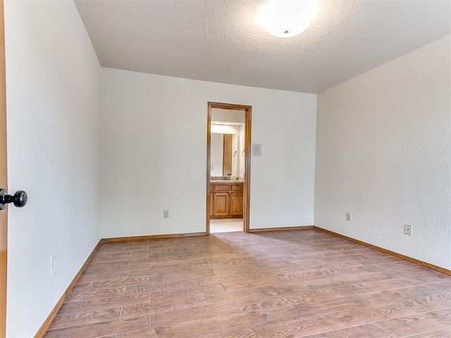 904 Carfax Rd, Edmond, OK 73034 - unfurnished room with light wood-style flooring and a textured ceiling