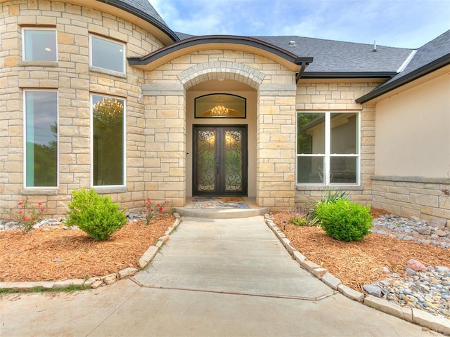 6209 Lakewood Ridge Rd, Edmond, OK 73013 - entrance to property featuring french doors, a shingled roof, and stone siding