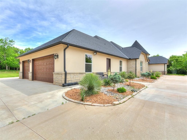 6209 Lakewood Ridge Rd, Edmond, OK 73013 - view of home's exterior featuring stone siding, driveway, a shingled roof, a garage, and stucco siding