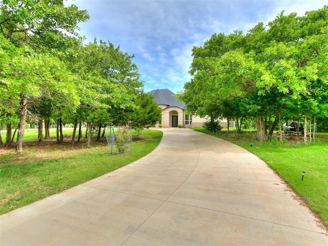 6209 Lakewood Ridge Rd, Edmond, OK 73013 - french country inspired facade with a front yard, stone siding, and driveway