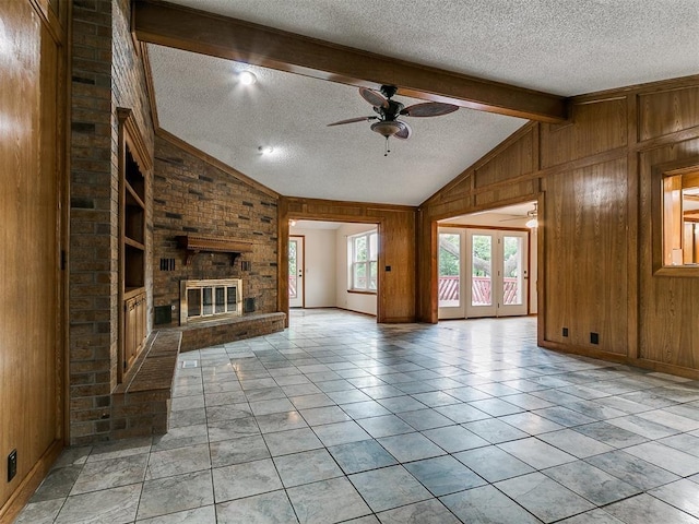 908 Carfax Rd, Edmond, OK 73034 - unfurnished living room featuring a textured ceiling, a ceiling fan, wooden walls, and a brick fireplace