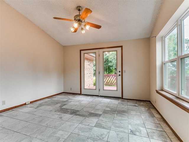 908 Carfax Rd, Edmond, OK 73034 - empty room featuring healthy amount of natural light, a textured ceiling, lofted ceiling, and a ceiling fan