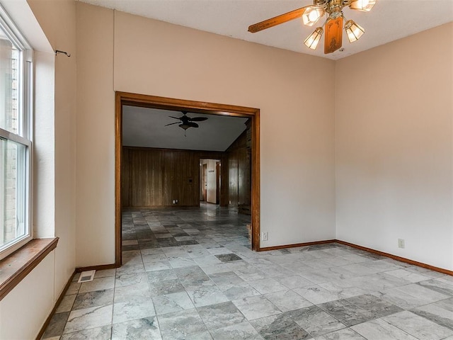 908 Carfax Rd, Edmond, OK 73034 - empty room featuring a ceiling fan and wood walls