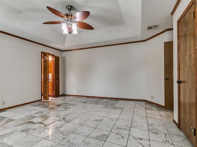 908 Carfax Rd, Edmond, OK 73034 - unfurnished room with a ceiling fan, a textured ceiling, a raised ceiling, crown molding, and light marble finish flooring