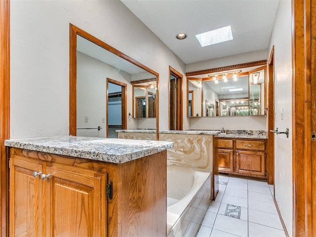 908 Carfax Rd, Edmond, OK 73034 - full bathroom featuring a skylight, vanity, a garden tub, and tile patterned flooring