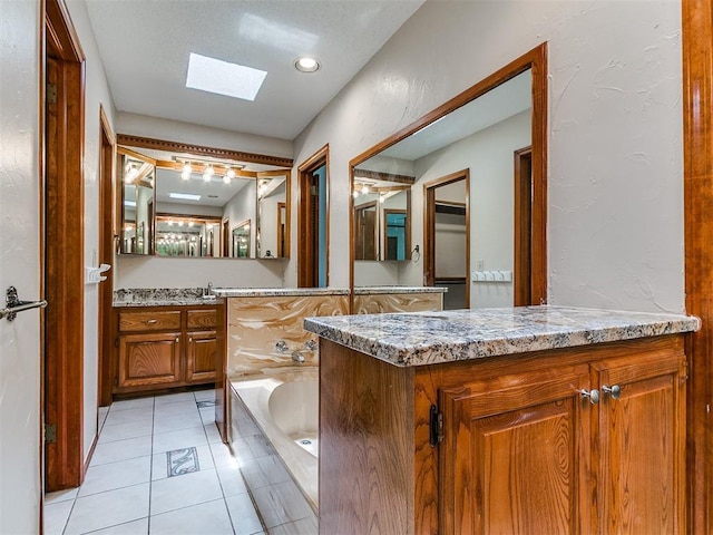 908 Carfax Rd, Edmond, OK 73034 - full bathroom with a skylight, a garden tub, vanity, and tile patterned floors