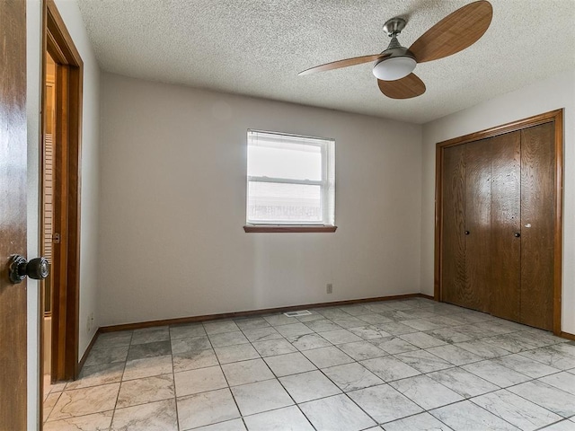 908 Carfax Rd, Edmond, OK 73034 - unfurnished bedroom with a textured ceiling, a closet, light tile patterned floors, and a ceiling fan
