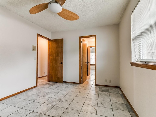 908 Carfax Rd, Edmond, OK 73034 - unfurnished bedroom featuring a textured ceiling and ceiling fan
