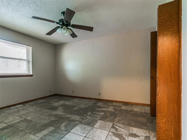 908 Carfax Rd, Edmond, OK 73034 - unfurnished room featuring a textured ceiling, ceiling fan, and stone finish flooring