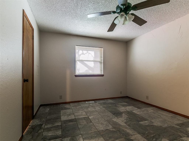 908 Carfax Rd, Edmond, OK 73034 - unfurnished room with a textured ceiling, a ceiling fan, and dark stone finish floors