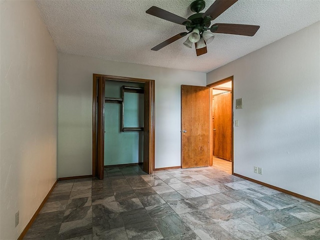 908 Carfax Rd, Edmond, OK 73034 - unfurnished bedroom featuring stone finish flooring, a closet, a textured ceiling, and a ceiling fan