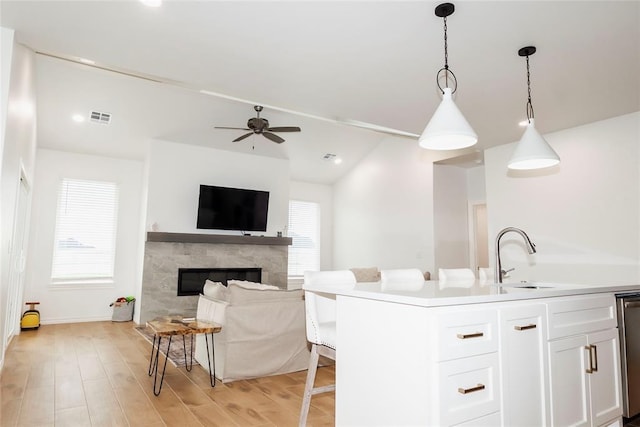 7310 S Brookwater Way, Stillwater, OK 74074 - kitchen featuring a ceiling fan, hanging light fixtures, visible vents, a sink, and white cabinets