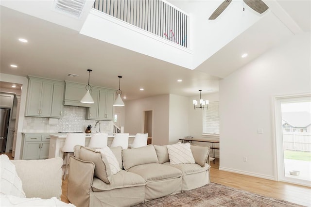 7310 S Brookwater Way, Stillwater, OK 74074 - living area featuring recessed lighting, visible vents, ceiling fan with notable chandelier, light wood-type flooring, and a high ceiling