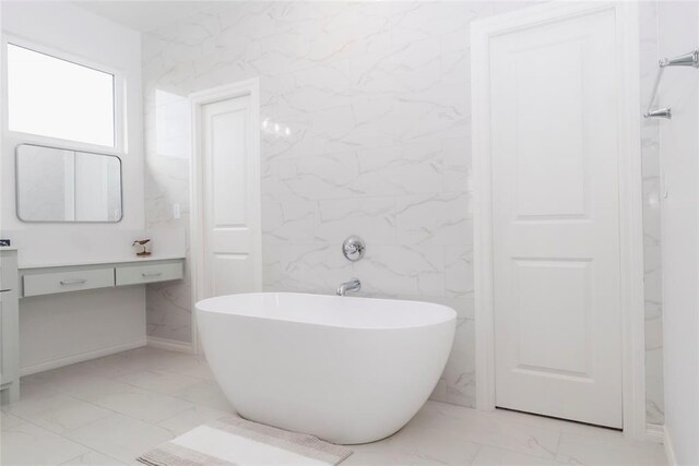 7310 S Brookwater Way, Stillwater, OK 74074 - bathroom with marble finish floor, a soaking tub, and vanity