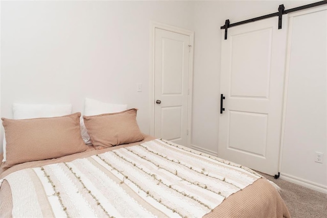 7310 S Brookwater Way, Stillwater, OK 74074 - carpeted bedroom with a barn door and baseboards