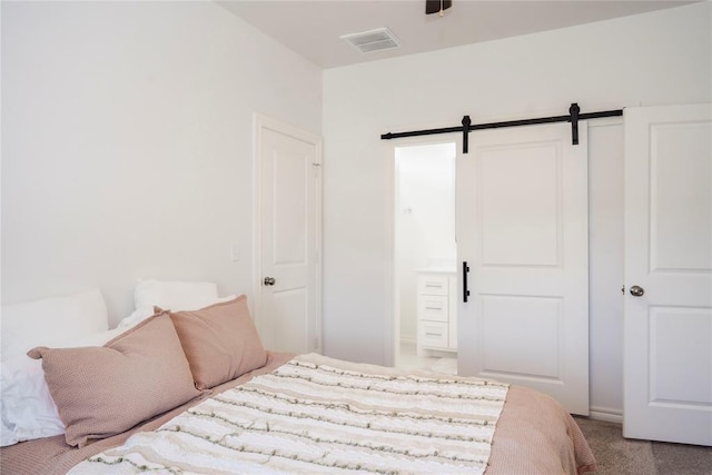 7310 S Brookwater Way, Stillwater, OK 74074 - carpeted bedroom featuring connected bathroom, visible vents, and a barn door
