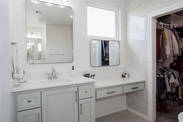 7310 S Brookwater Way, Stillwater, OK 74074 - bathroom with a spacious closet, vanity, and visible vents