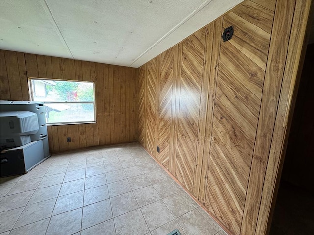 interior space featuring wooden walls and light tile patterned flooring
