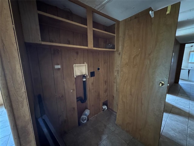 laundry area with wood walls and tile patterned floors