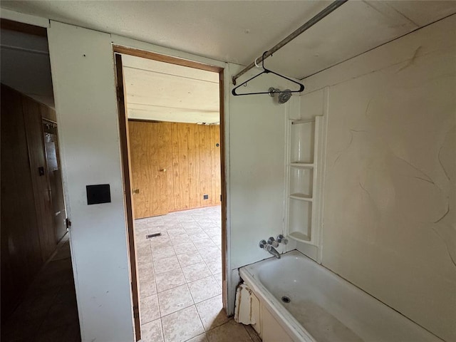bathroom featuring bathing tub / shower combination and wooden walls