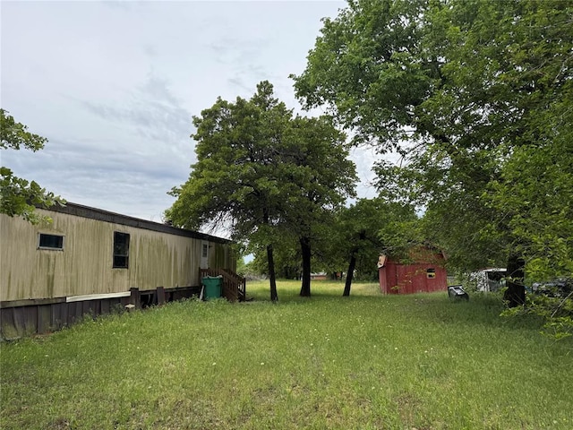 view of yard featuring a storage shed and an outbuilding