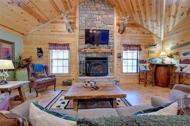 living room with vaulted ceiling, wooden ceiling, wood walls, plenty of natural light, and a stone fireplace