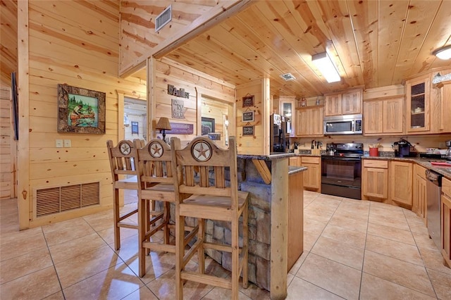 kitchen featuring appliances with stainless steel finishes, wooden ceiling, light tile patterned floors, glass insert cabinets, and light brown cabinetry