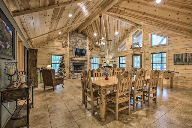 dining space featuring wood ceiling, high vaulted ceiling, a fireplace, wooden walls, and tile patterned flooring