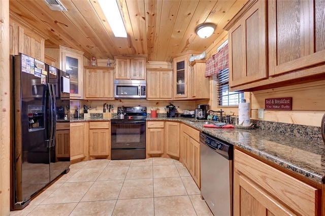 kitchen with black appliances, wood ceiling, a sink, light tile patterned floors, and dark stone countertops