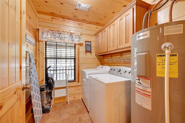 washroom featuring cabinet space, water heater, washing machine and clothes dryer, wooden walls, and wooden ceiling