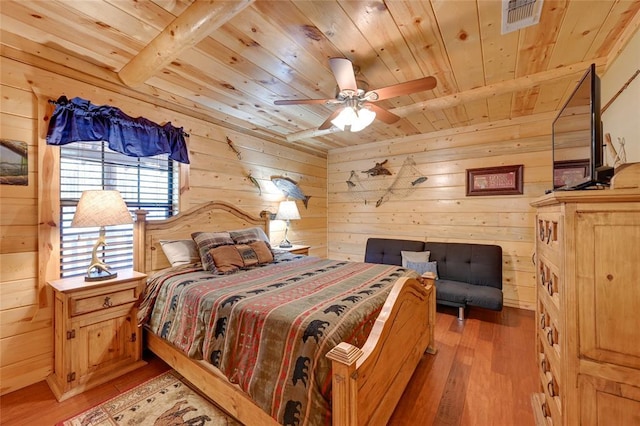 bedroom with wooden ceiling, wooden walls, light wood-style flooring, and ceiling fan