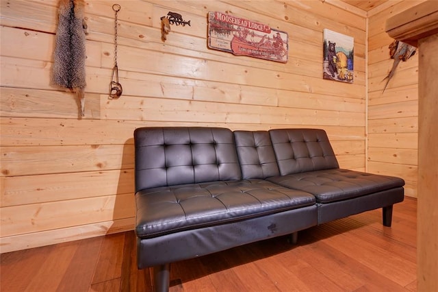 sitting room with wooden walls and wood finished floors